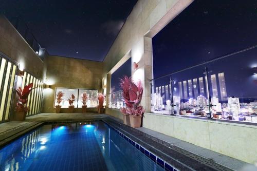 a swimming pool in a building with a city at Ashton Hotel in Ulsan