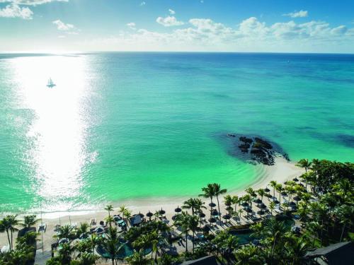 an aerial view of a beach with palm trees and the ocean at Royal Palm Beachcomber Luxury in Grand Baie