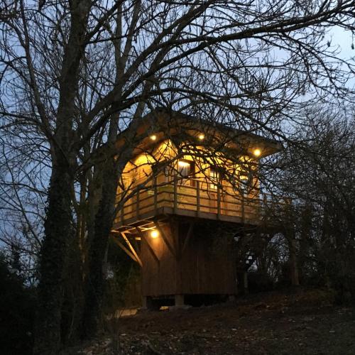 a tree house with lights on top of it at Cabane perchee in Vert