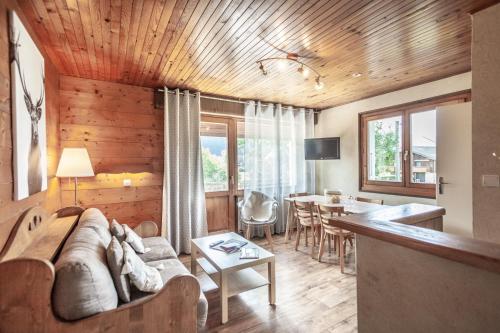ein Wohnzimmer mit einem Sofa und einem Tisch in der Unterkunft Giffre et Clesson in Samoëns