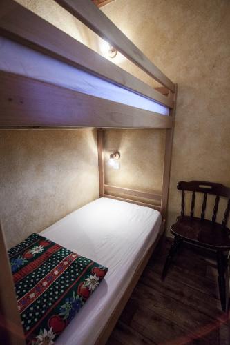a bedroom with a bunk bed and a chair at Appartements Giffre et Clesson - DAHU COMPAGNIE in Samoëns