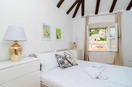 a bedroom with a white bed and white walls at Cinema View House in Dubrovnik