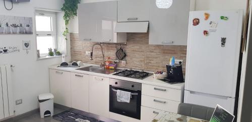 una cucina bianca con lavandino e piano cottura di AMaTa House a Taranto