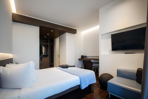 a hotel room with a bed and a chair at Domotel Kastri in Athens