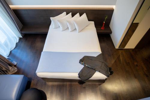 a white bed with pillows on it in a room at Domotel Kastri in Athens