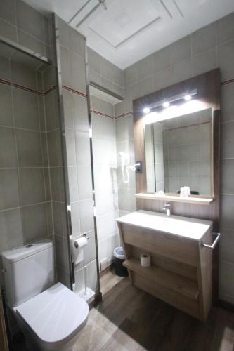 a bathroom with a toilet and a sink and a mirror at Hotel, H de l'Anton in Batea