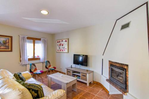 a living room with a couch and a fireplace at Cómodo y coqueto chalet con jardín en Argoños in Argoños