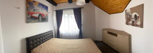 een slaapkamer met een bed en een raam bij Apartament Ella in Rîşnov