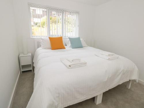 a white bed with two towels on top of it at Little Starboard in Kingsbridge