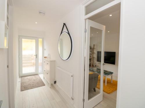 a white hallway with a mirror on the wall at Little Starboard in Kingsbridge