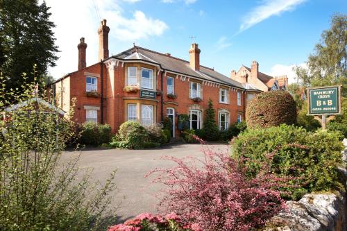 une maison en briques avec un panneau devant elle dans l'établissement Banbury Cross B&B, à Banbury