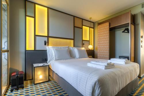 a bedroom with a large white bed in a room at The Convo Porto Hotel & Suites in Porto