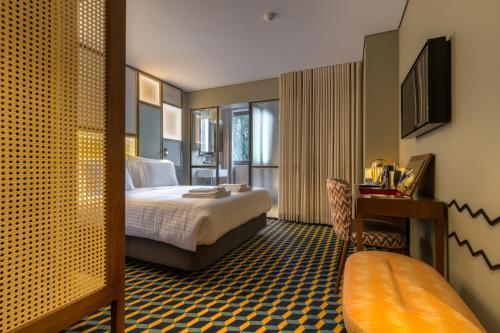 a hotel room with a bed and a desk at The Convo Porto Hotel & Suites in Porto