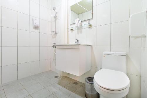 永康區的住宿－台南華南商旅，白色的浴室设有卫生间和镜子