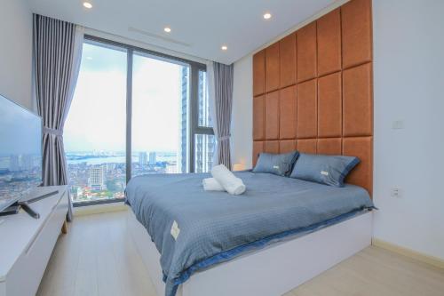 a bedroom with a large bed and large windows at Vinhomes Metropolis Hanoi - CitiHome in Hanoi