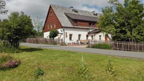 een groot wit huis met een houten hek bij Ferienwohnung Wagner in Kurort Altenberg