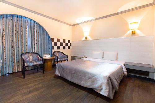 永康區的住宿－台南華南商旅，酒店客房,配有一张床和两把椅子