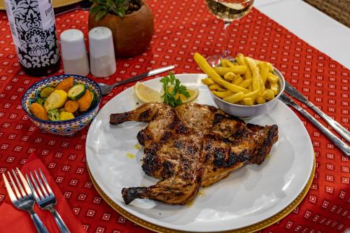 a plate of meat and french fries on a table at Nkomazi Kruger Lodge & Spa in Malelane