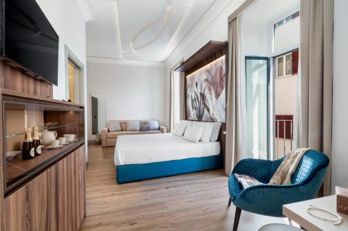 Habitación de hotel con cama y sofá en Elys Suites en Sorrento