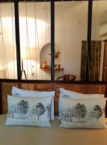 two white pillows sitting on top of a couch at Herdade da Diabroria - Agroturismo in Beja