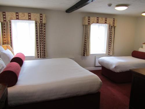 a hotel room with two beds and two windows at Windmill Village Hotel, Golf Club & Spa, BW Signature Collection in Coventry