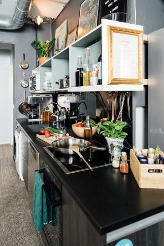 a kitchen with a black counter top and a sink at The Yard Hostel in Helsinki