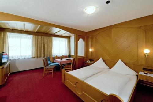 a hotel room with a large bed and a television at Hotel Lasalt in Ischgl