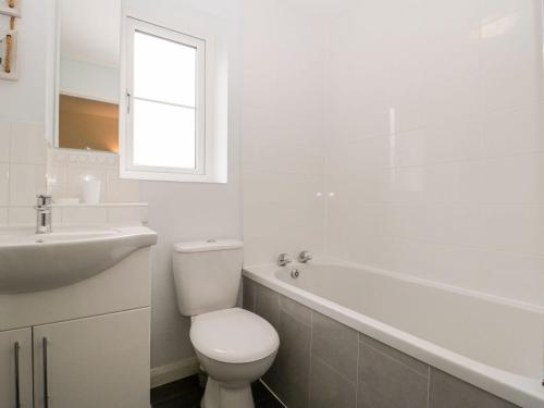 La salle de bains blanche est pourvue de toilettes et d'un lavabo. dans l'établissement Littledown, à Bournemouth