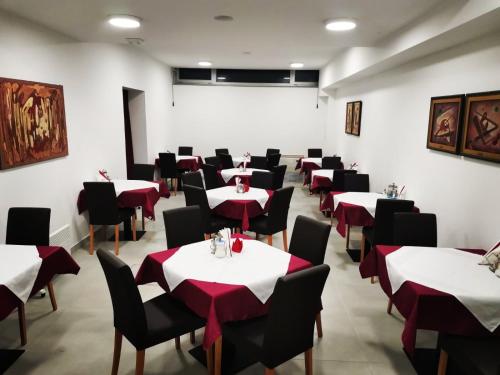 a dining room with red and white tables and chairs at Hotel Slavija Banja Luka in Banja Luka