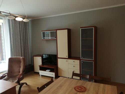 a living room with a table and a cabinet and a tv at Apartament Słoneczny in Ustroń
