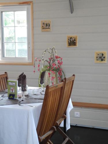 a dining room with a table with a vase of flowers at Hotel Des Neiges in Cilaos