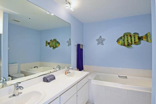 a bathroom with two sinks and a tub and a mirror at On the Beach, Walk to Village, Watch the Sunsets from Balcony in Siesta Key