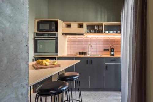 a kitchen with two bar stools and a counter top at Cohort Koukaki in Athens