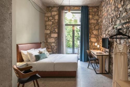 1 dormitorio con cama, escritorio y ventana en Cohort Koukaki en Athens