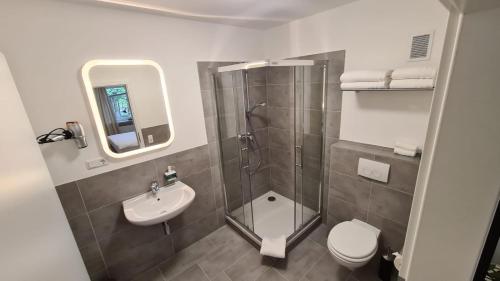 ein Badezimmer mit Dusche, Toilette und Waschbecken in der Unterkunft Moes Diner Hotel in Schloß Holte-Stukenbrock