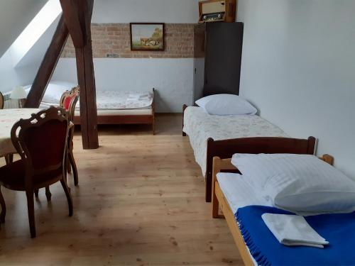 a room with two beds and a table and chairs at Apartament ogrodowy in Rydzewo