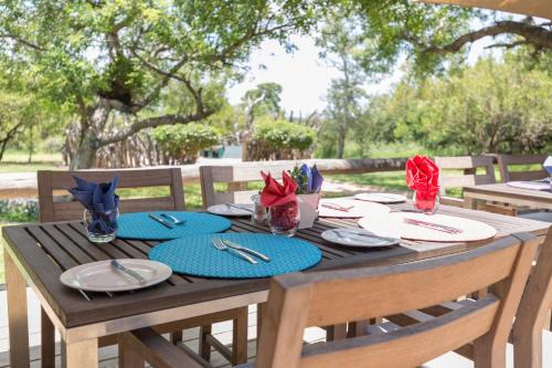 a wooden table with plates and napkins on it at Baobab Ridge in Klaserie Private Nature Reserve