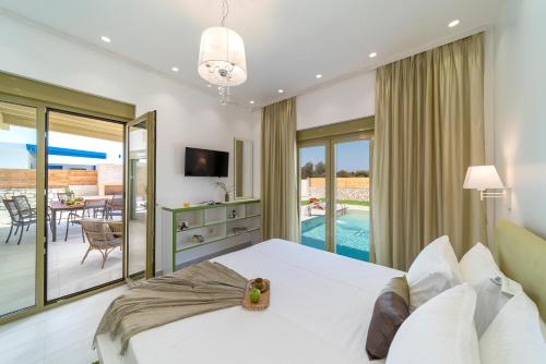 a bedroom with a bed and a living room at Serenity Villas in Kolimbia