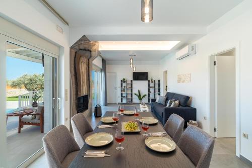 a dining room and living room with a table and chairs at Serenity Villas in Kolimbia