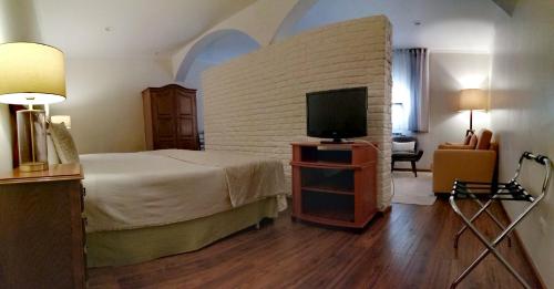 a bedroom with a bed and a flat screen tv at Herdade da Diabroria - Agroturismo in Beja