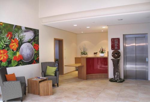 a hospital lobby with chairs and a reception desk at Landhotel Wilder Mann in Eggingen