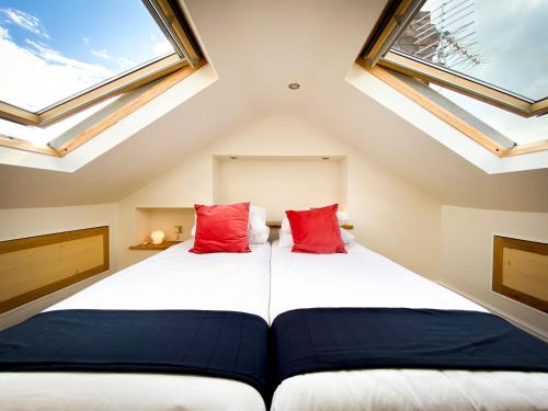 a attic bedroom with two beds with skylights at Nomi Homes - Powderham - Exeter - Uni - Free parking - Central in Exeter