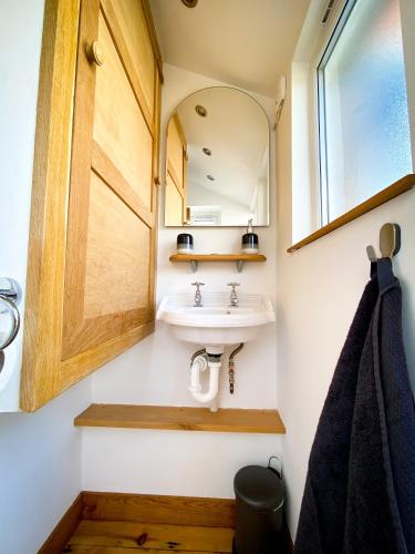 a bathroom with a sink and a mirror at Nomi Homes - Powderham - Exeter - Uni - Free parking - Central in Exeter