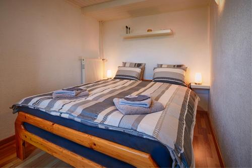 1 dormitorio con 1 cama grande y toallas. en Chez Marie-Claude en Vendlincourt