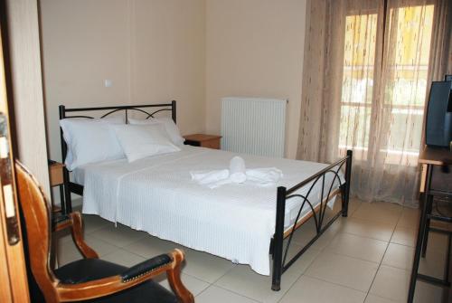 ein Schlafzimmer mit einem Bett, einem Stuhl und einem TV in der Unterkunft Villa Maria in Ierissós