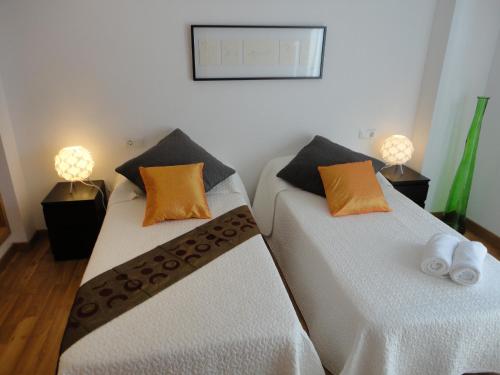 - deux lits assis l'un à côté de l'autre dans une pièce dans l'établissement Residencial Suites Valldemossa - Turismo de Interior, à Valldemossa