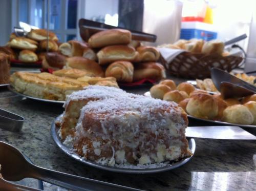 a table with plates of pastries and other pastries at Hotel Arrastão in São Sebastião