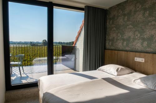 a bedroom with a bed and a view of a balcony at Hotel De Zes Bochten in Knokke-Heist
