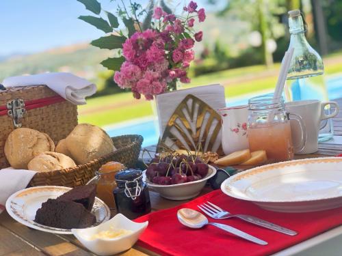 einen Picknicktisch mit Essen, Brot und Blumen in der Unterkunft Lugar nas Estrelas in Peso