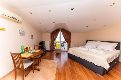 a bedroom with a bed and a table in a room at Apartments Artan in Crikvenica